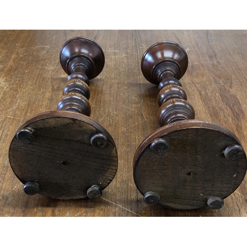 8289 - A pair of oak candlesticks, 41cm high overall.