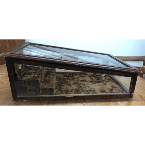 8290 - A display cabinet with key, brown fabric interior, 62cm deep, 46cm wide, 23cm high overall.