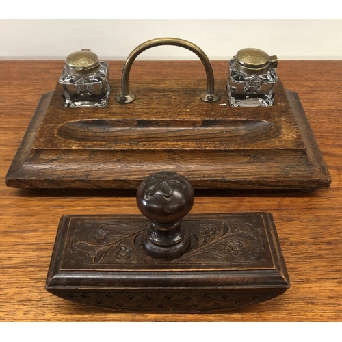 8295 - An oak inkwell stand with 2 glass ink bottles and a carved wood blotter.