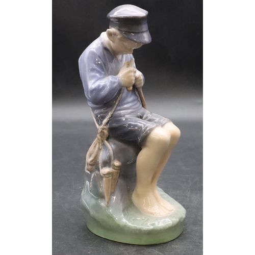 103 - A Royal Copenhagen figure of a young seated boy whittling a stick, number 905, 18.5cm high