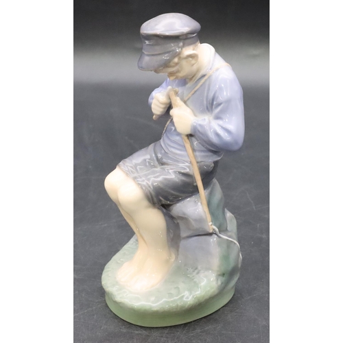 103 - A Royal Copenhagen figure of a young seated boy whittling a stick, number 905, 18.5cm high