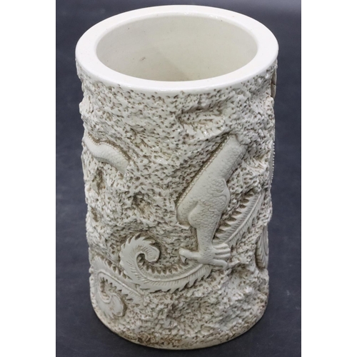 110 - An Oriental white glazed brush pot with raised dragon and Phoenix decoration on white ground, 15cm h... 