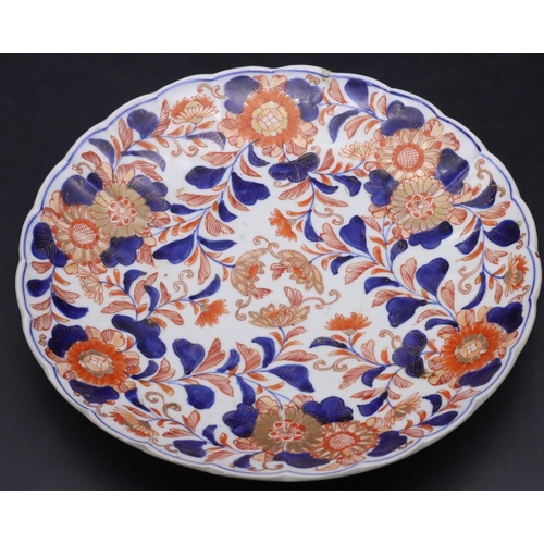 114 - An Imari round scallop shaped dish on white, red and blue ground with allover floral, leaf and gilt ... 