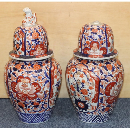 124 - A pair of Imari round bulbous lidded ginger jars on white, red and blue ground with allover floral, ... 