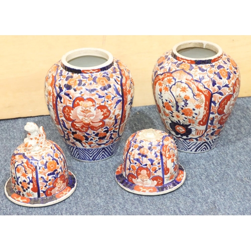 124 - A pair of Imari round bulbous lidded ginger jars on white, red and blue ground with allover floral, ... 