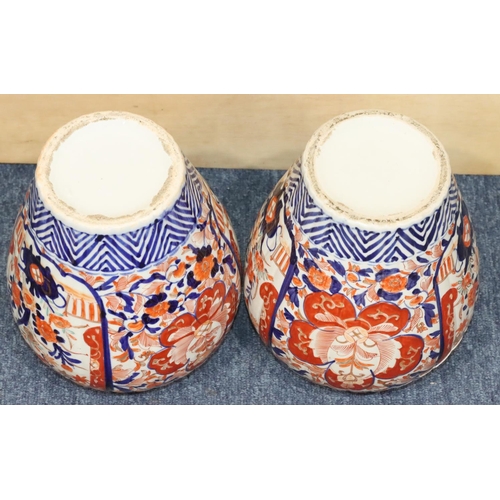 124 - A pair of Imari round bulbous lidded ginger jars on white, red and blue ground with allover floral, ... 