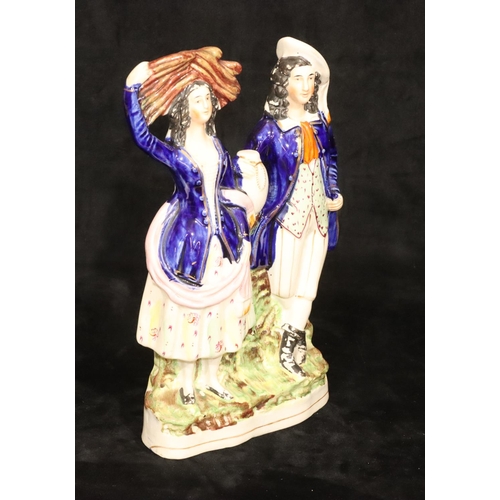 135 - A large 19th Century Staffordshire group of a standing gentleman and lady with blue jackets, 32cm hi... 