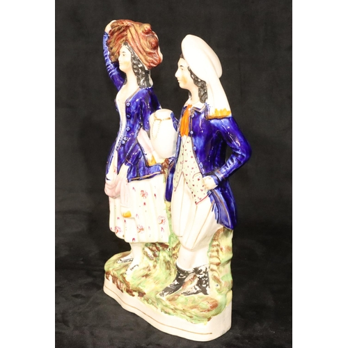 135 - A large 19th Century Staffordshire group of a standing gentleman and lady with blue jackets, 32cm hi... 