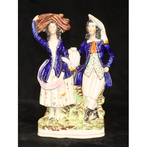 135 - A large 19th Century Staffordshire group of a standing gentleman and lady with blue jackets, 32cm hi... 