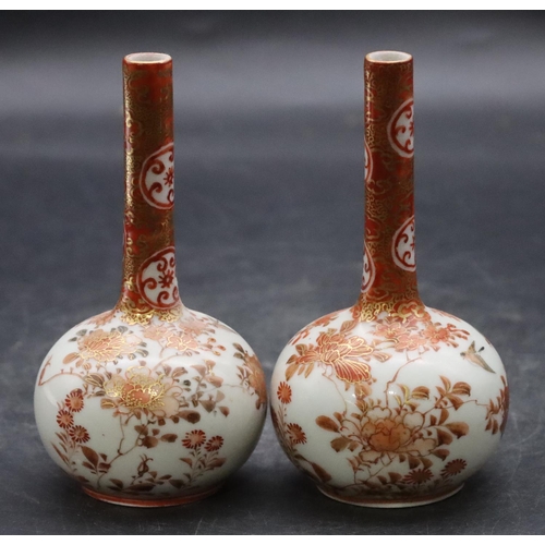 138 - A pair of Oriental small round bulbous thin necked vases on white and red ground with coloured bird,... 