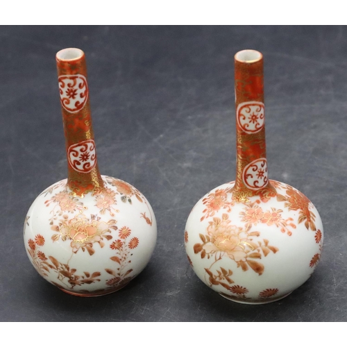 138 - A pair of Oriental small round bulbous thin necked vases on white and red ground with coloured bird,... 