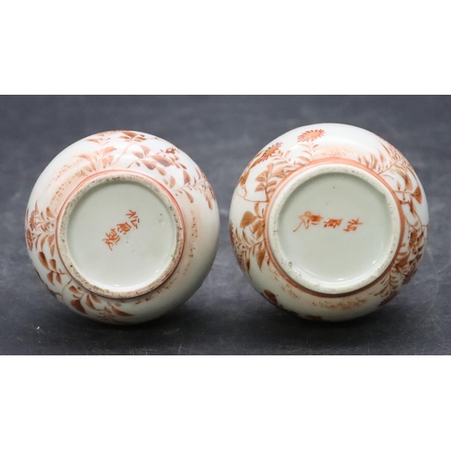 138 - A pair of Oriental small round bulbous thin necked vases on white and red ground with coloured bird,... 