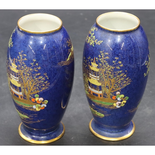 14 - A pair of Carlton ware small round bulbous thin necked vases on blue ground with multi-coloured will... 