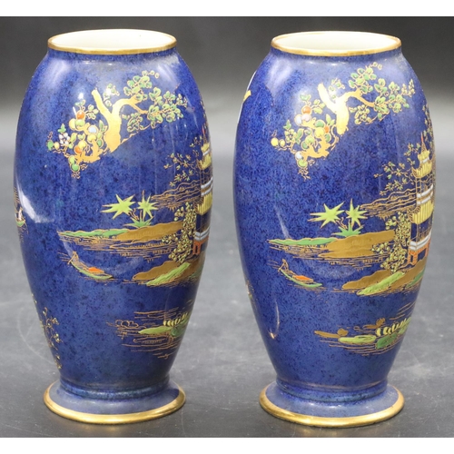 14 - A pair of Carlton ware small round bulbous thin necked vases on blue ground with multi-coloured will... 