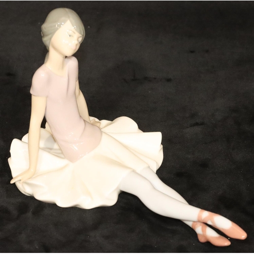 145 - A Lladro figure of a seated ballerina, 15cm high, 25cm long