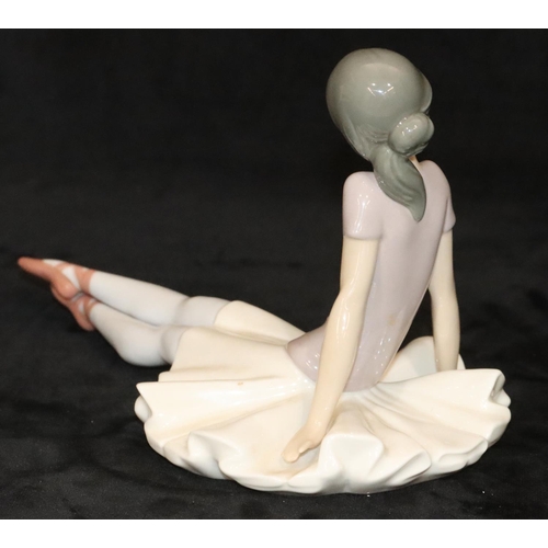 145 - A Lladro figure of a seated ballerina, 15cm high, 25cm long