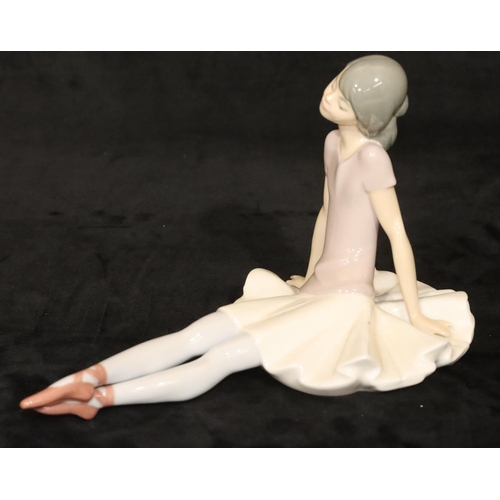 145 - A Lladro figure of a seated ballerina, 15cm high, 25cm long