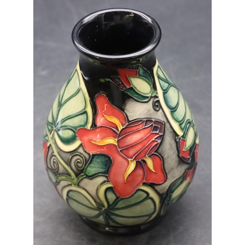 159 - A modern Moorcroft small round bulbous thin necked vase on dark blue ground with multi-coloured flor... 