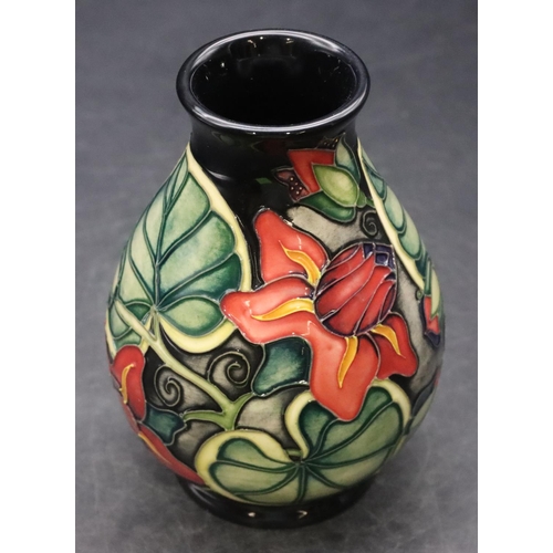 159 - A modern Moorcroft small round bulbous thin necked vase on dark blue ground with multi-coloured flor... 