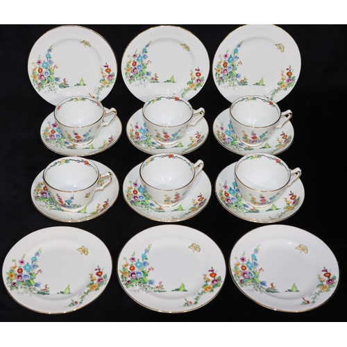 16 - A Crown Staffordshire tea service on white ground with multi-coloured butterfly, floral and garden d... 