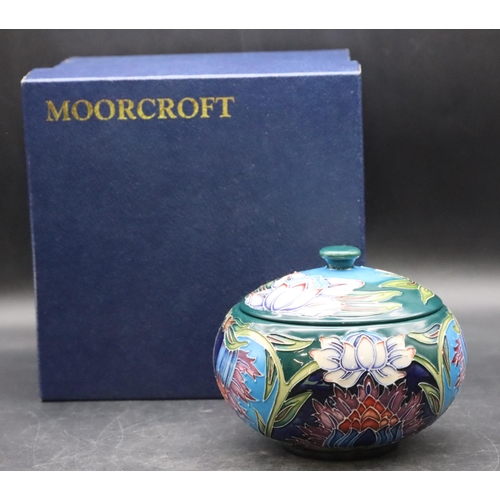 160 - A modern Moorcroft round bulbous lidded pot on turquoise and green ground with multi-coloured floral... 