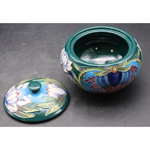 160 - A modern Moorcroft round bulbous lidded pot on turquoise and green ground with multi-coloured floral... 