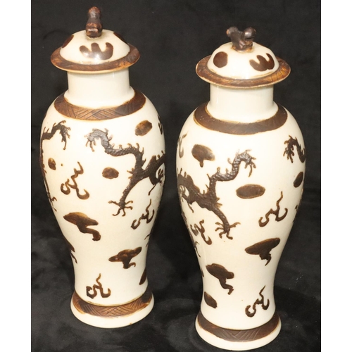 172 - A pair of Chinese round bulbous thin necked lidded vases on white ground with raised brown, dragon a... 