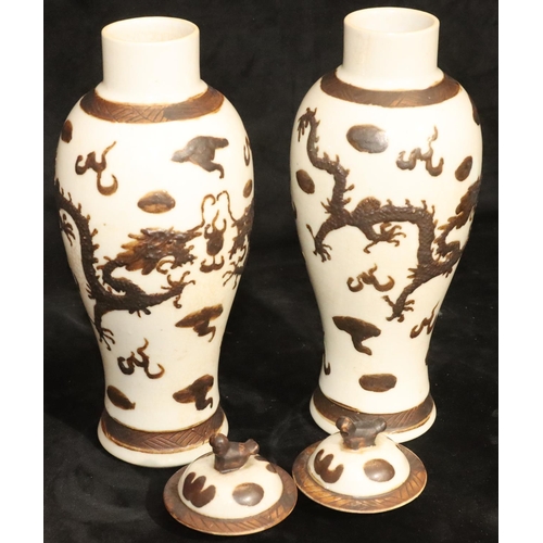 172 - A pair of Chinese round bulbous thin necked lidded vases on white ground with raised brown, dragon a... 