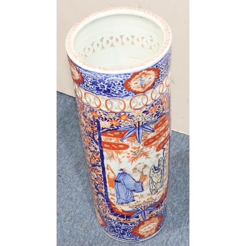 185 - An Imari cylindrical umbrella stand with pierced rim on white, red and blue ground and allover figur... 