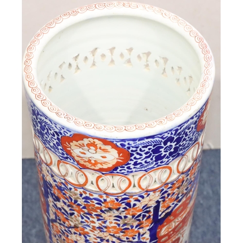 185 - An Imari cylindrical umbrella stand with pierced rim on white, red and blue ground and allover figur... 