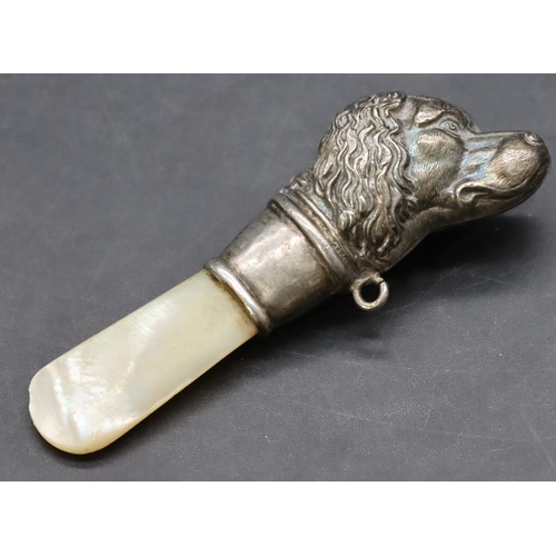 245 - A child's silver and Mother of Pearl rattle in the form of a dog's head (bell missing and teeth mark... 