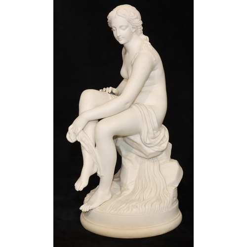 47 - A Parian figure of a female seated nude, on round base, 43cm high (Right leg restored just above ank... 