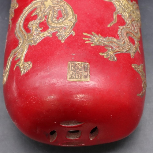 50 - An Oriental earthenware pillow in the form of a bag on red ground with gilt dragon decoration, 33cm ... 