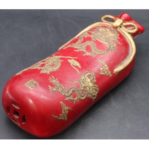 50 - An Oriental earthenware pillow in the form of a bag on red ground with gilt dragon decoration, 33cm ... 