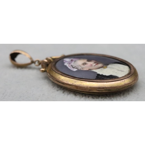 519 - A 9ct gold oval double sided locket, depicting portrait of a gentleman and lady, 5.2cm high overall,... 