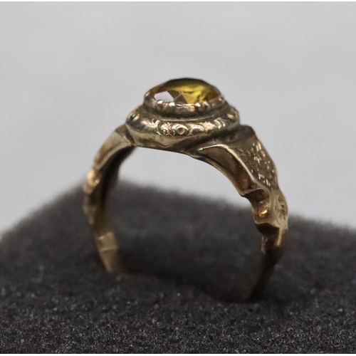 520 - A 19th Century gold ring set with Citrine style stone with allover chased floral and leaf decoration... 