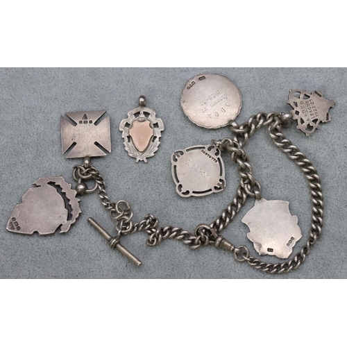 537 - A silver watch chain mounted with 7 silver badges, 81.8 grams gross