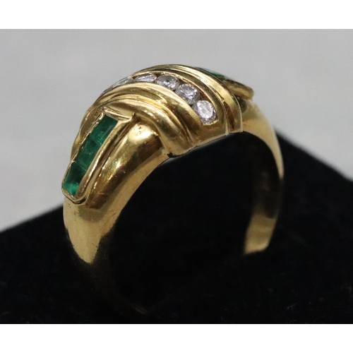 542 - An 18ct gold ladies' ring with a row of 6 graduated small diamonds flanked by 5 square cut emeralds,... 