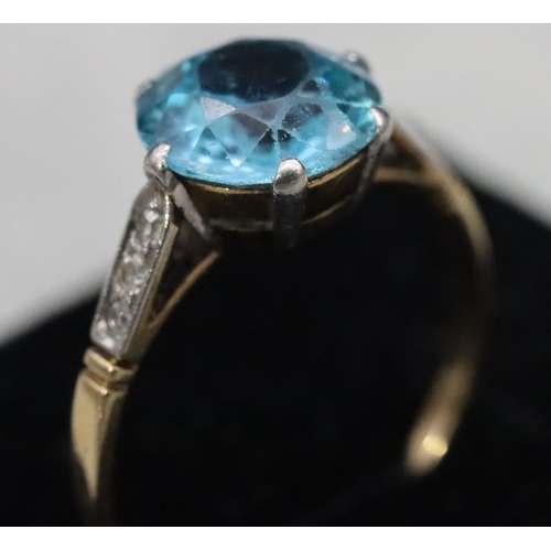 556 - A blue Zircon ladies' ring, flanked by 6 diamond chips to shoulders, (approx. 2.50ct), Size O, 2.5 g... 