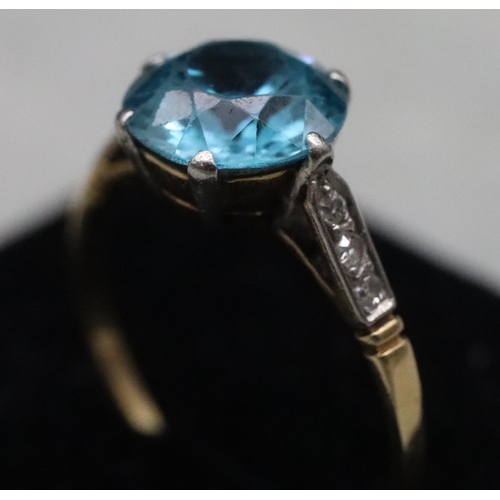 556 - A blue Zircon ladies' ring, flanked by 6 diamond chips to shoulders, (approx. 2.50ct), Size O, 2.5 g... 