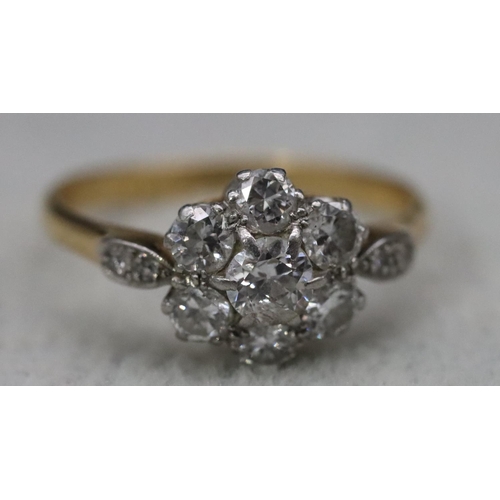 557 - An 18ct gold and platinum ladies' cluster ring set with centre diamond surrounded by 6 small diamond... 