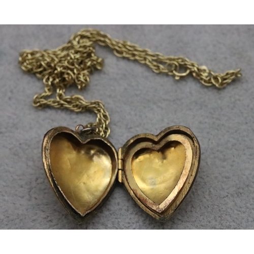 566 - A 9ct gold front and back heart shaped locket with embossed floral motif, mounted on 9ct gold chain ... 