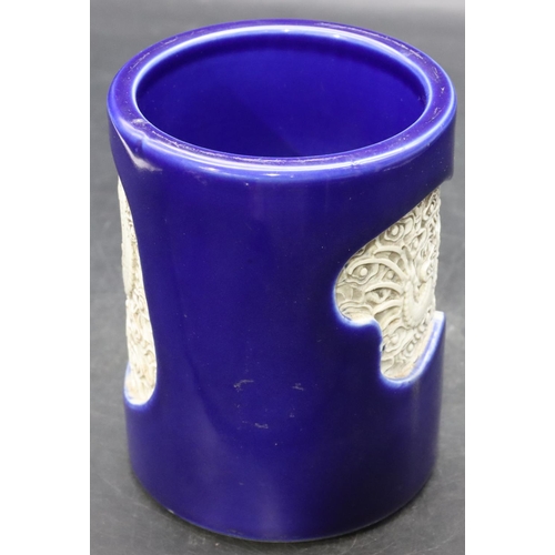 57 - An Oriental cylindrical brush pot on blue ground with inserted white dragon decoration, 14cm high