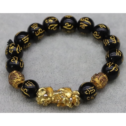 588 - An Oriental black bead expanding strap bracelet