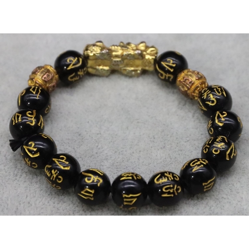 588 - An Oriental black bead expanding strap bracelet