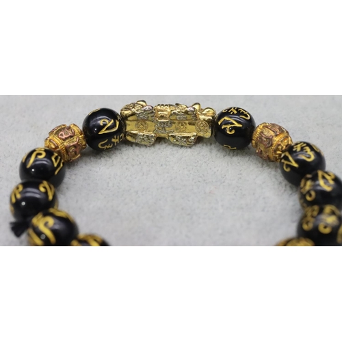 588 - An Oriental black bead expanding strap bracelet