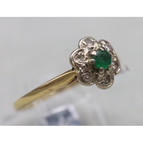 594 - A ladies' gold cluster ring set with centre emeralds surrounded by small diamond chips, Size M, 2 gr... 