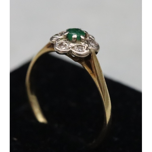 594 - A ladies' gold cluster ring set with centre emeralds surrounded by small diamond chips, Size M, 2 gr... 