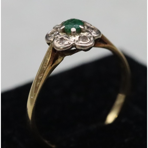 594 - A ladies' gold cluster ring set with centre emeralds surrounded by small diamond chips, Size M, 2 gr... 