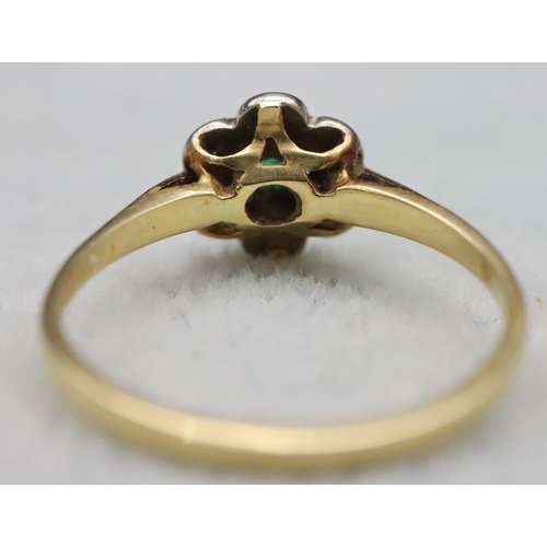 594 - A ladies' gold cluster ring set with centre emeralds surrounded by small diamond chips, Size M, 2 gr... 